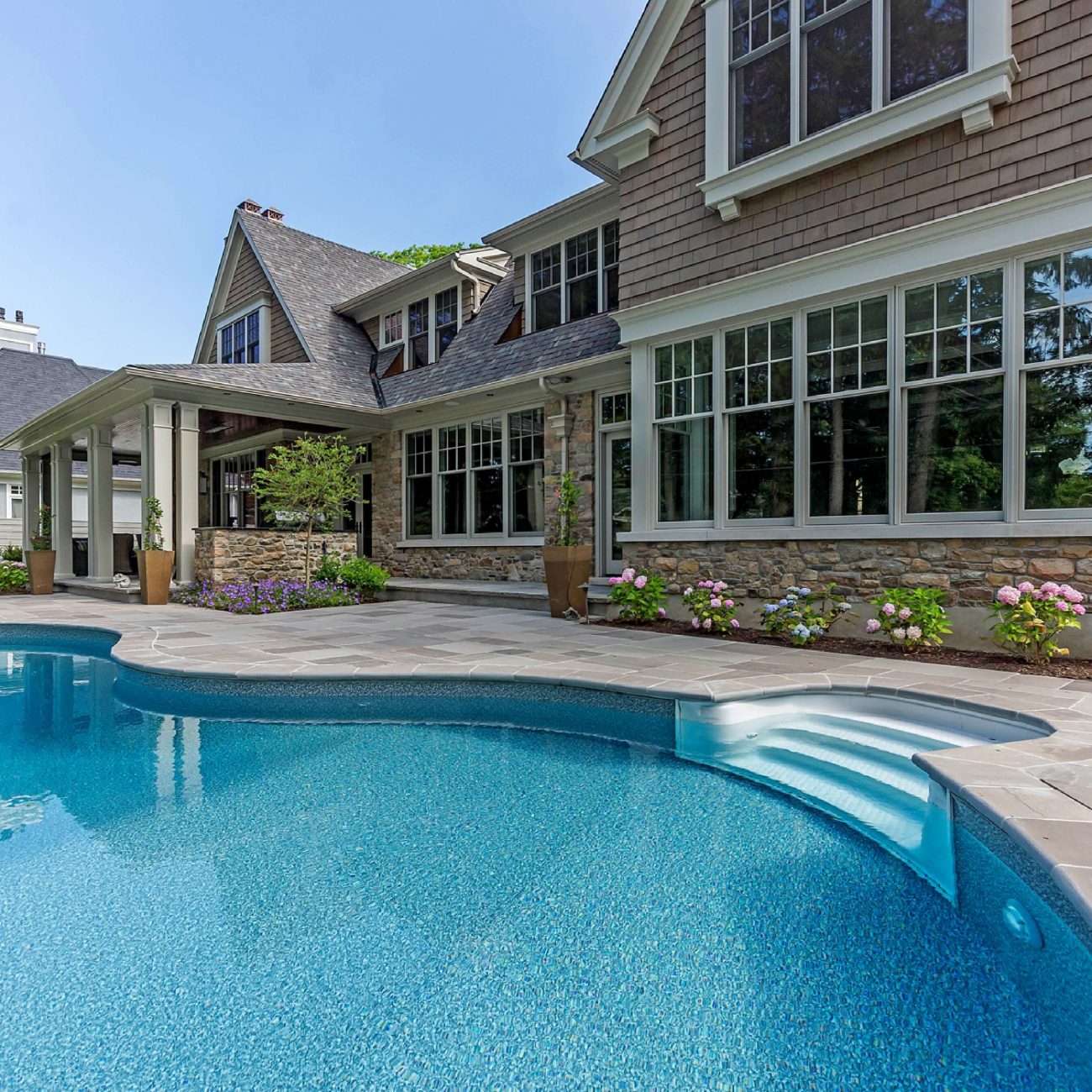 A house with a swimming pool and patio, custom luxury pool