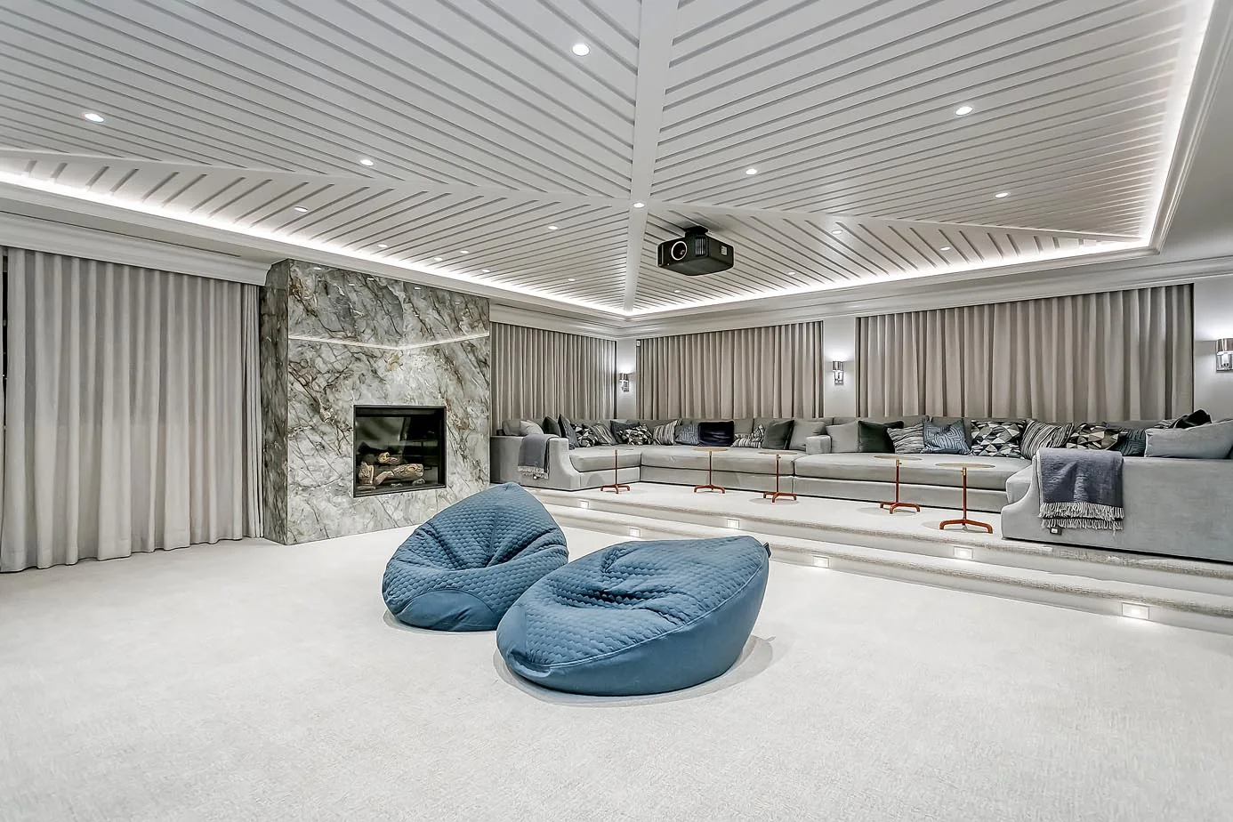 An east Oakville home theater with blue bean bags and a fireplace overlooking the lakefront, Sustainable Custom Luxury Home