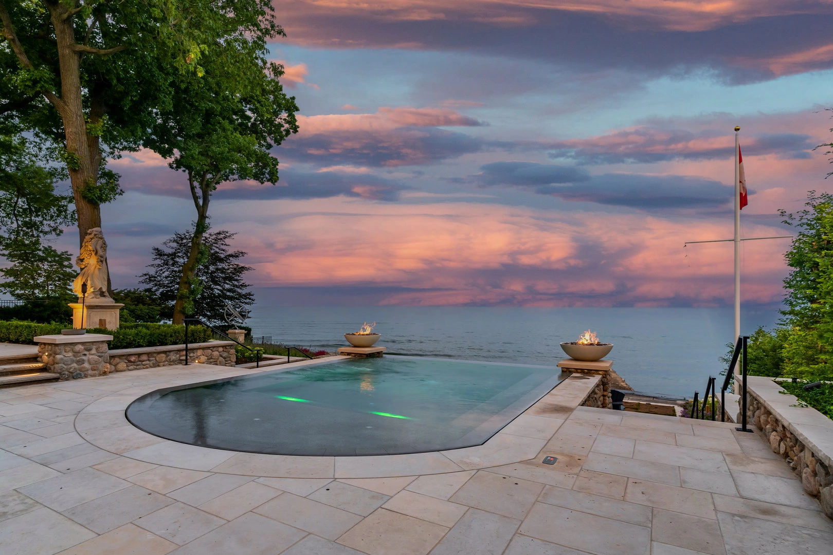 A East Oakville lakefront pool with a view of the ocean at sunset, custom luxury pool